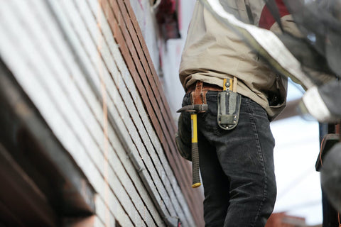tradesman on ladders with a toolbelt