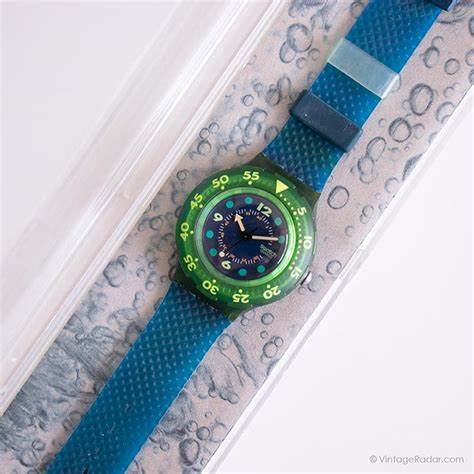 In 1991 Swatch released the SDN100 BLUE MOON  a sleek blue dial with pink hands and green hour marks, as well as with a dark-green bezel and an original textured strap.