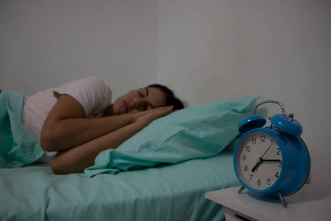 A Woman with clock showing The Importance of Sleep for Reducing Anxiety
