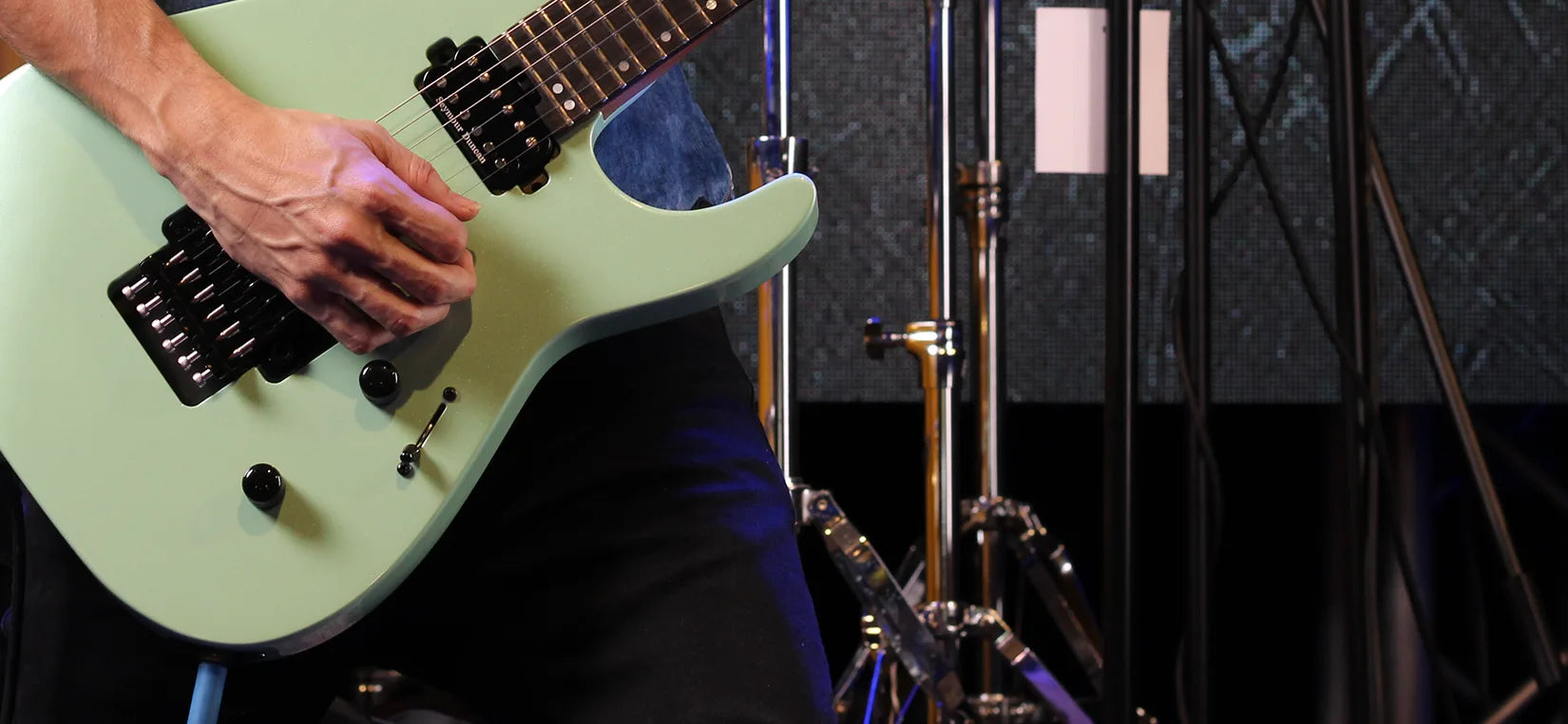 guitarra electrica verde siendo tocada por un guitarrista
