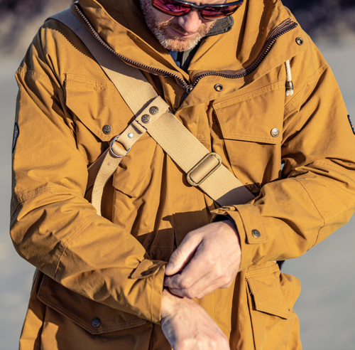 Man checking watch on a Scottish beach wearing a cumin colour Shimi smock