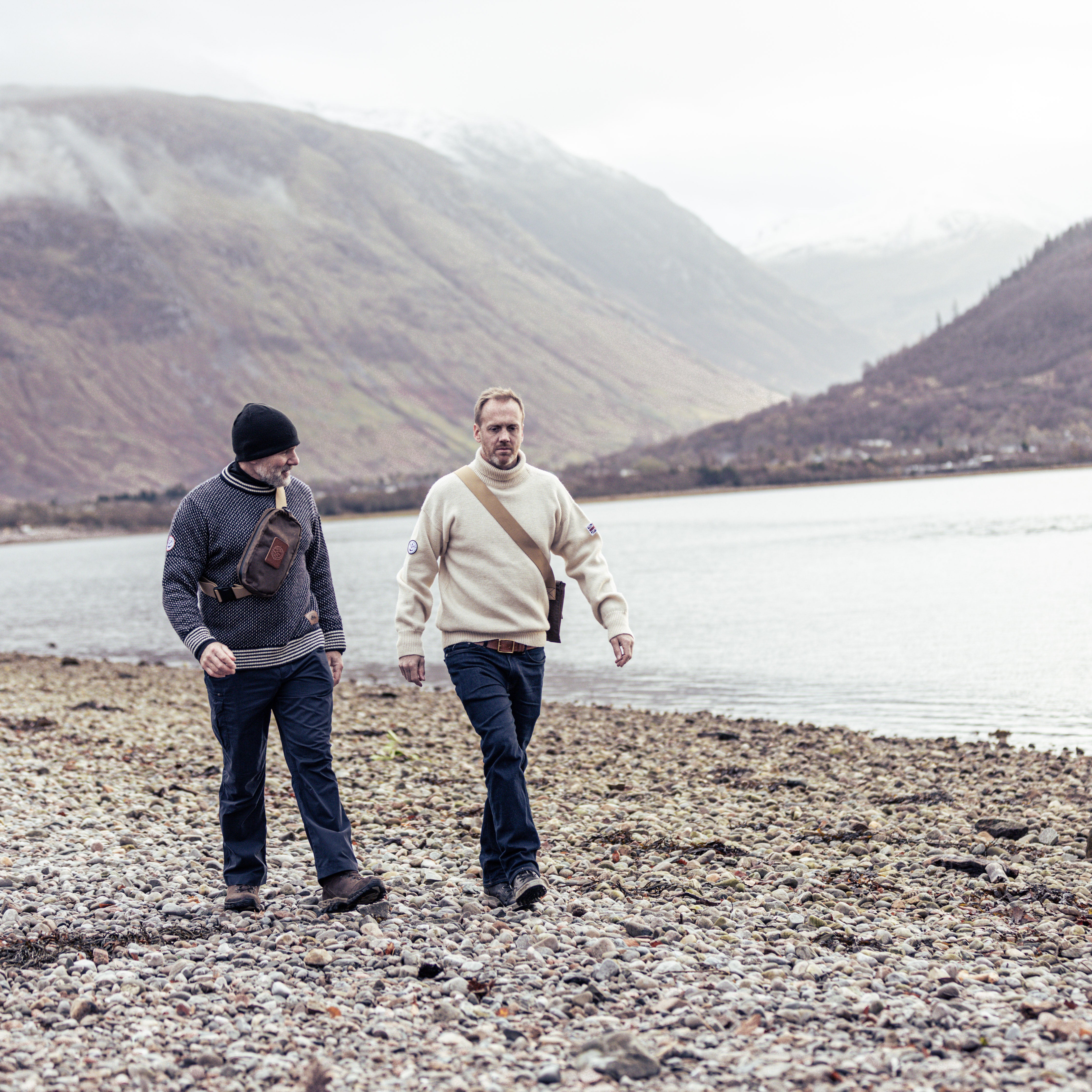 2 men walking on the cobbled beach at Corpach, Scotland