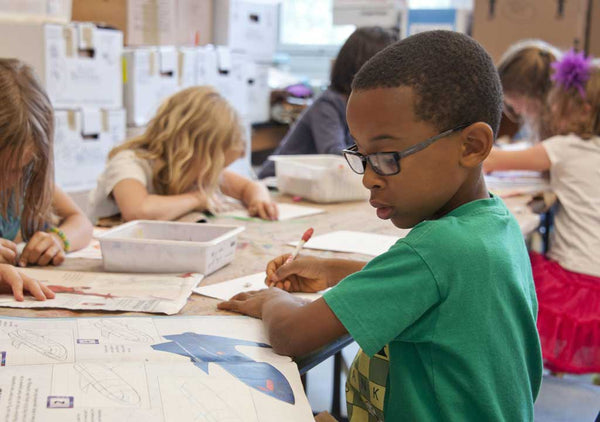 Child drawing on desk.