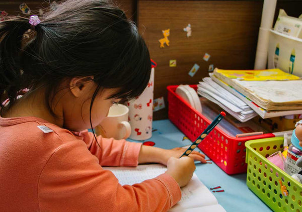 Girl writing on desk.