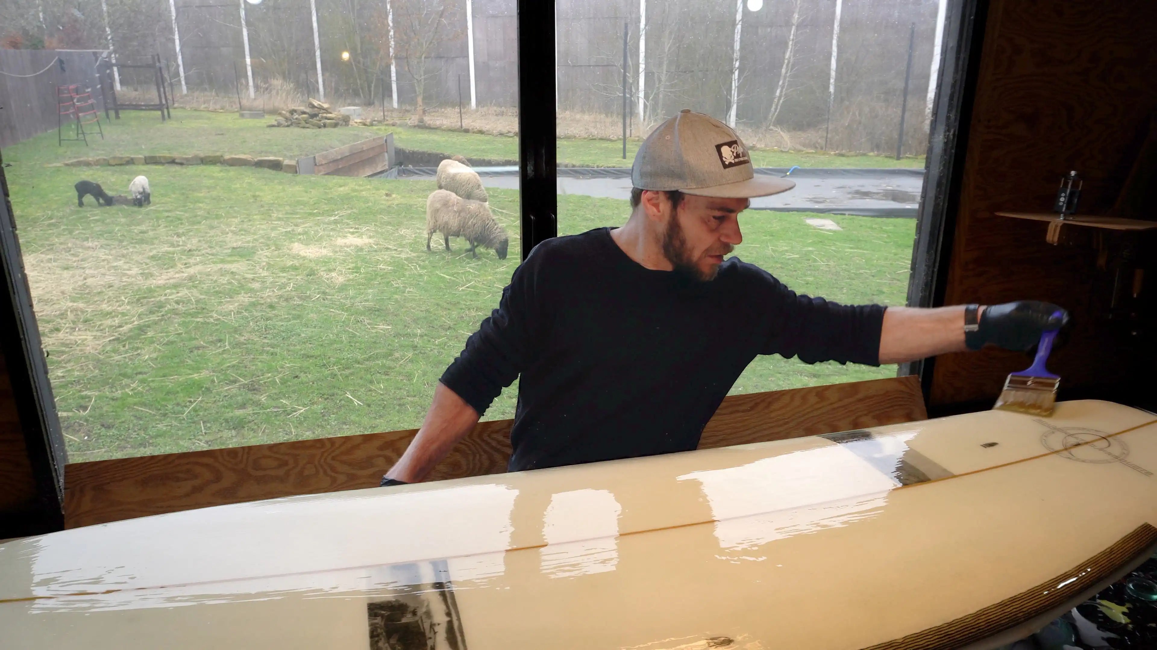 Shaper Martin Brandýs stands in his workshop, P.E.F. surfboards, river surfboard shaper, sheep