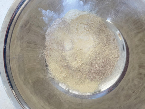 Dry ingredients and protein powder added to a bowl