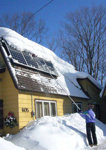 Snow rake being used on solar panels