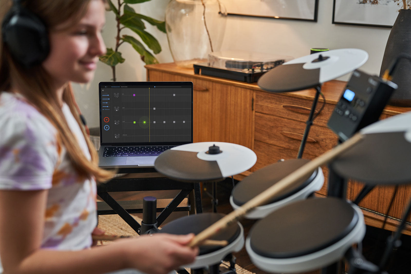 Drummer using with Melodics app on laptop computer while playing TD-02KV