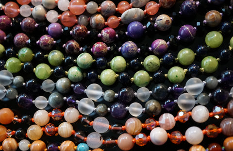 Several colorful malas lined up like bones in the spine. These designs are available now on the MMM online shop.