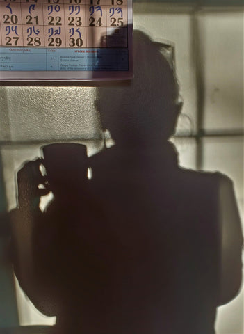 Silhouette of me holding a cup of tea while looking at the November calendar.