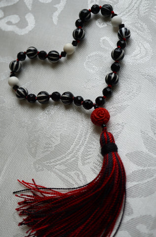 Red Rose Quarter Mala with Black and White Striped Agate, Faceted Onyx, and Matte Mother-of-Pearl beads and red rose guru with black and red tassel.