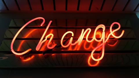 The word "Change" in bright orange neon against a dark background