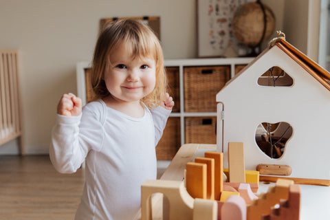 Kid playing in playhouse with small kitchen set.