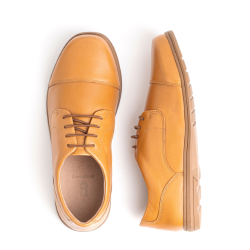 A pair of tan leather dress shoes on a white background.