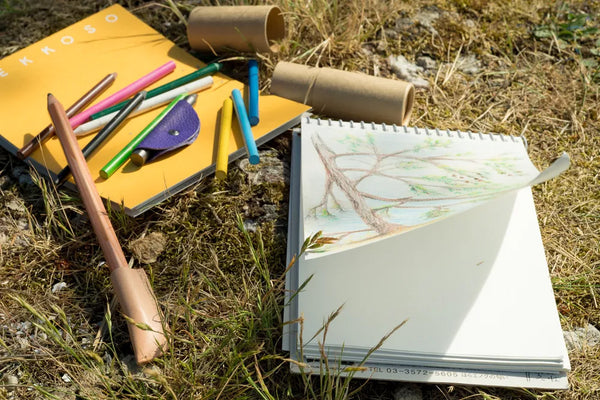 Gekkoso sketchbook with drawing of a tree next to colored drawing pencils