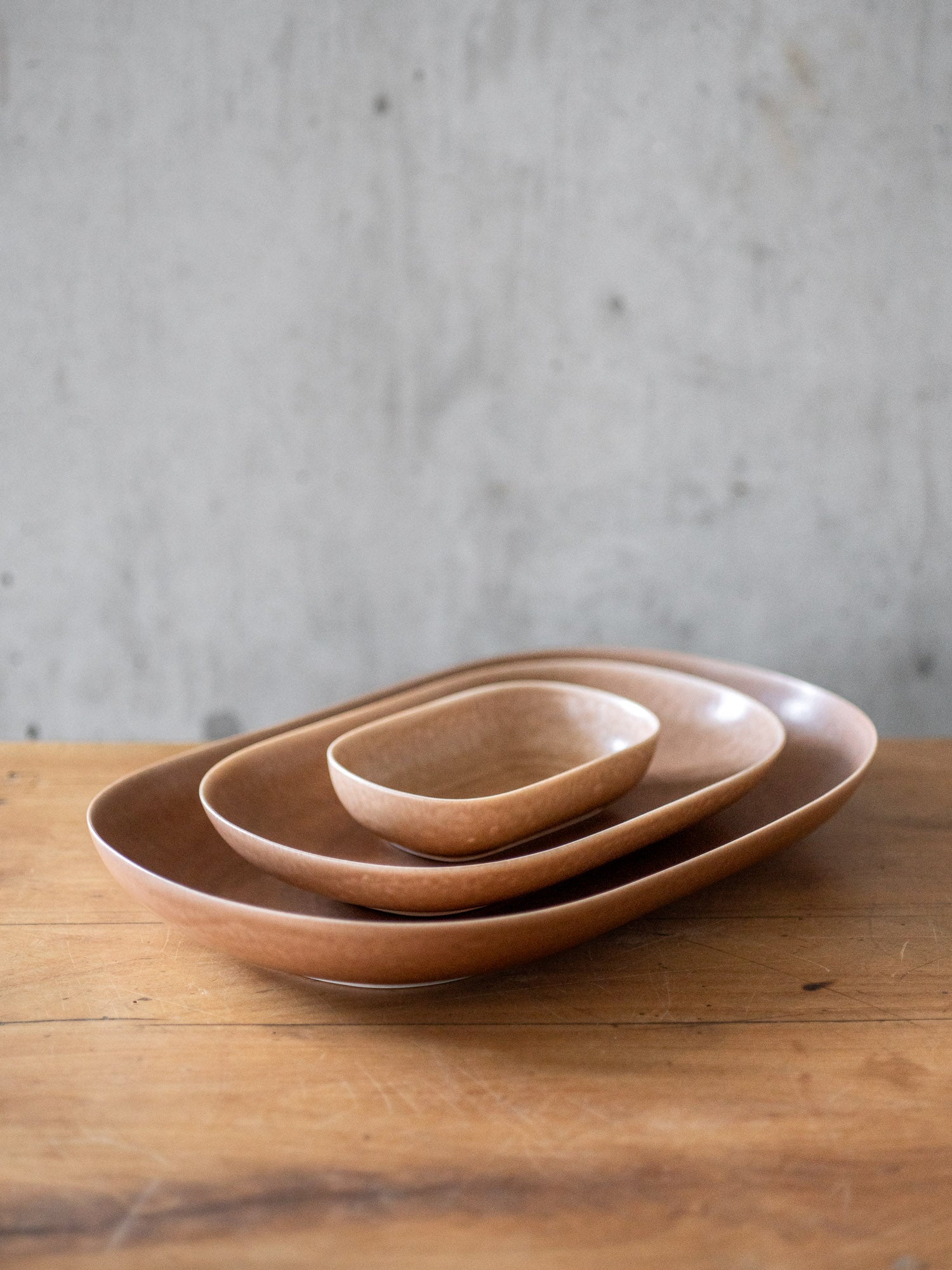 https://cdn.shopify.com/s/files/1/0782/7498/6292/files/yumiko-iihoshi-brown-porcelain-oval-serving-plates.jpg?v=1695867114&width=1500