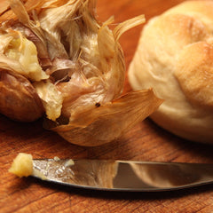 A roasted smoked garlic bulb served with crusty bread