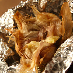 A roasted smoked garlic bulb in foil just removed from oven