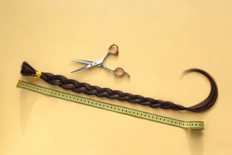 Braid of hair next to a tape measure