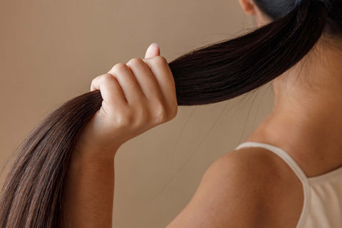 Woman holding her ponytail in her hand