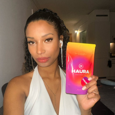 'Person holding a product with 'HAURA' branding, posing for the camera.'