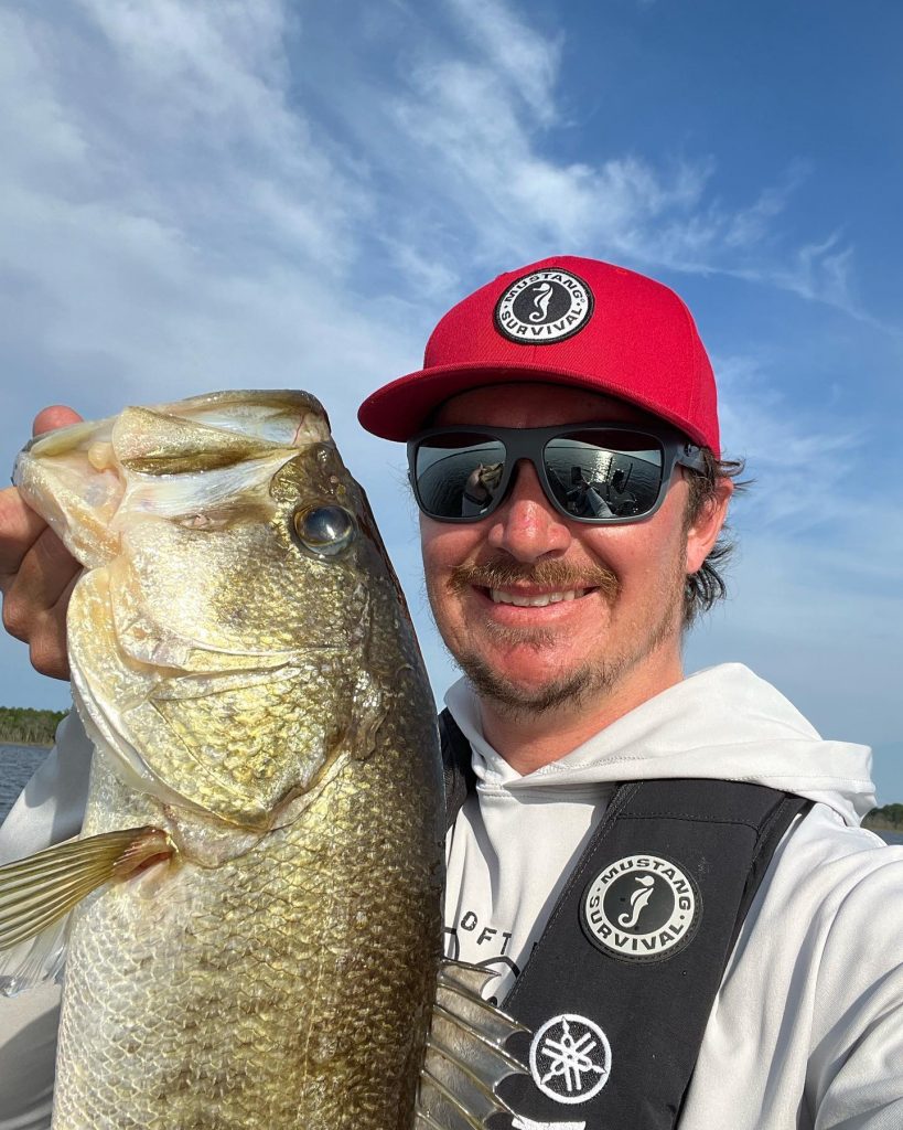 Hunter Bland, boating safety advocate, posing with a Bass