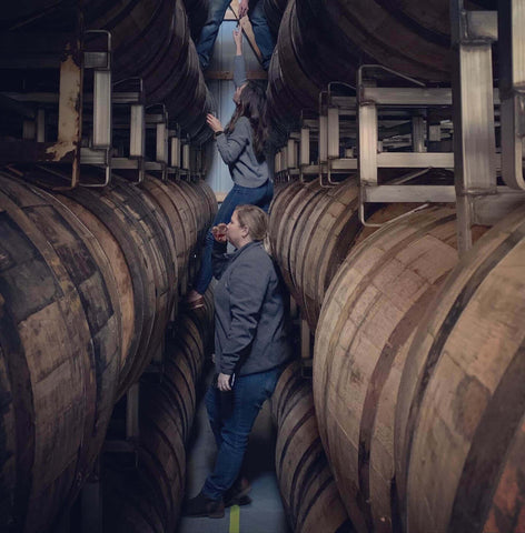 Ashley Barnes and Monica Wolf looking through KOKORO whiskey Barrels