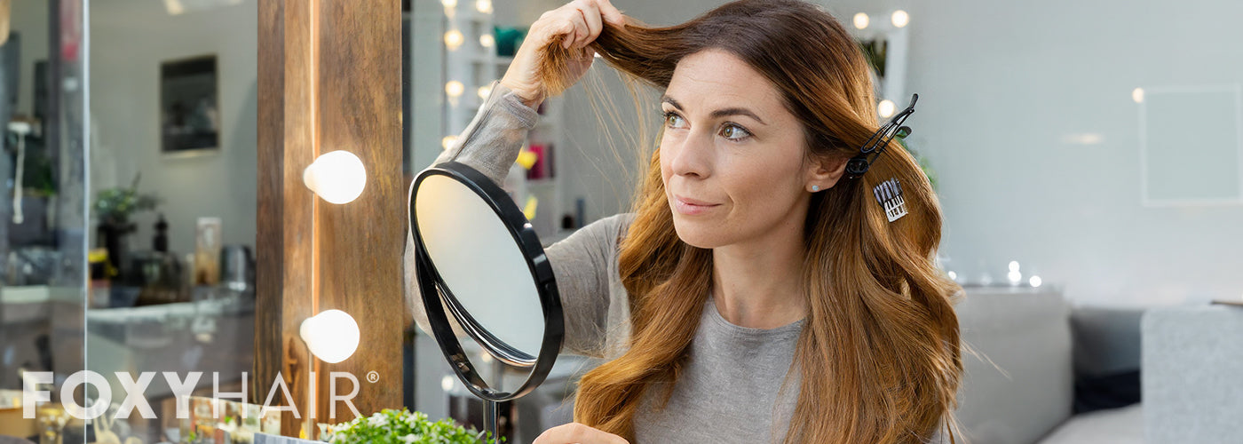 Woman frustrated looking in mirror as hair extensions dont match