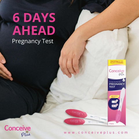 Conceive Plus Early Pregnancy Test strips and packing in the forefront and a woman in black dress sitting in the background half visible without the face