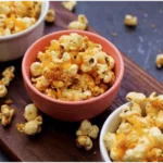 Three bowls of buttered popcorn.