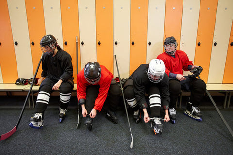 Hockey team preparing equipment with focus on shin pad maintenance, exploring can you wash hockey shin pads.