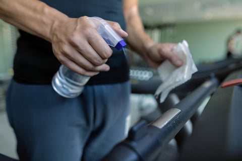 Disinfecting gym equipment to prevent skin infections.