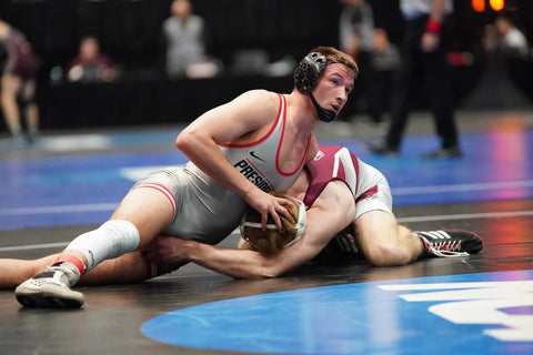 Photo of wrestlers engaging in a match on sanitized mats, demonstrating preventive measures against ringworm in sports and highlighting how do you keep ringworm from spreading.