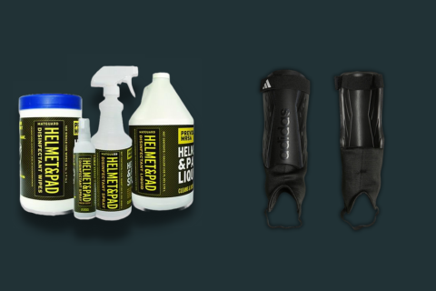 Assorted soccer shin pads cleaning supplies including Matguard disinfectant spray and wipes, soft brush, mild soap, and cloth on a table