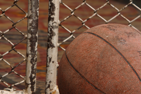 Close-up image of a dirty basketball on a basketball court, highlighting the need for cleaning