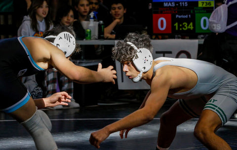 Wrestlers demonstrating close contact during a match, highlighting risk factors for skin infections.