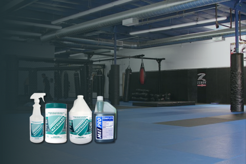 A range of Matguard cleaning products displayed on the edge of a BJJ mat, ready for use to maintain hygiene and safety.