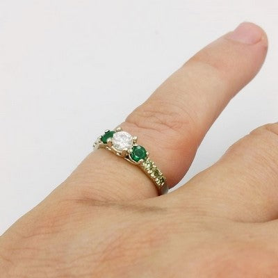 anillo de compromiso de esmeralda en el dedo