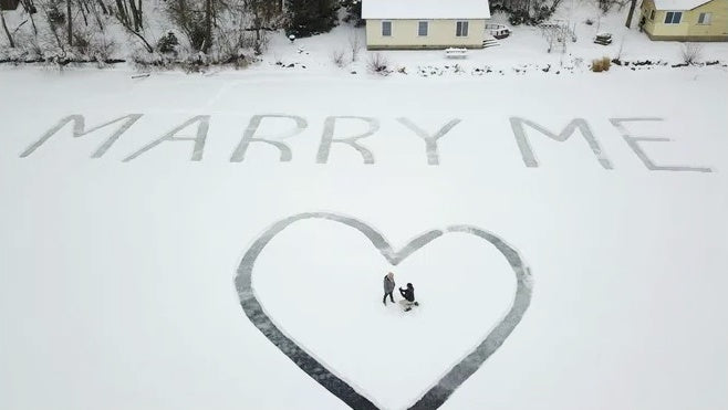 propuesta de matrimonio con pregunta escrita en la nieve
