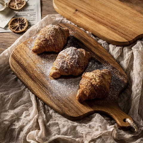Pravero snijplank met handvat, ideaal voor het serveren van versgebakken croissants. De stevige houten plank heeft een natuurlijke uitstraling en is perfect voor zowel snijden als presenteren in de keuken of op tafel.