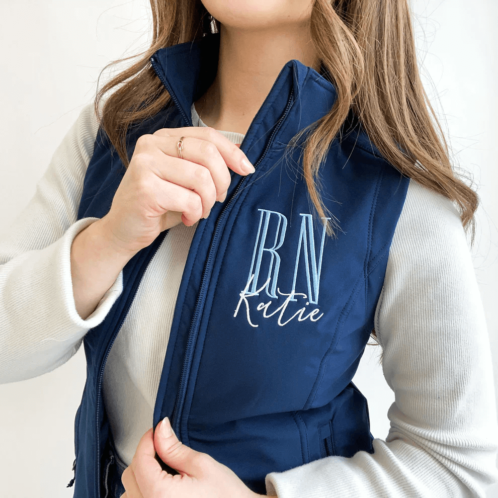 Woman wearing navy blue vest with white long-sleeve shirt