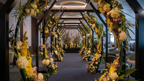 Mise en scène florale pour un événement important. Arc de passage pour le public sous des décorations florales.