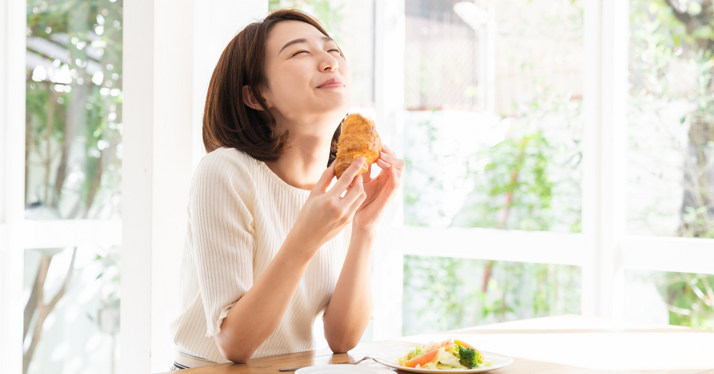 パンを美味しそうに食べている女性