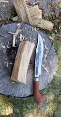 using large knife to shape wooden stock for machete handle