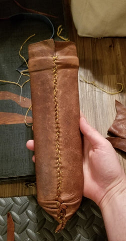 stitching up the leather wrap after gluing it to the leather sheath
