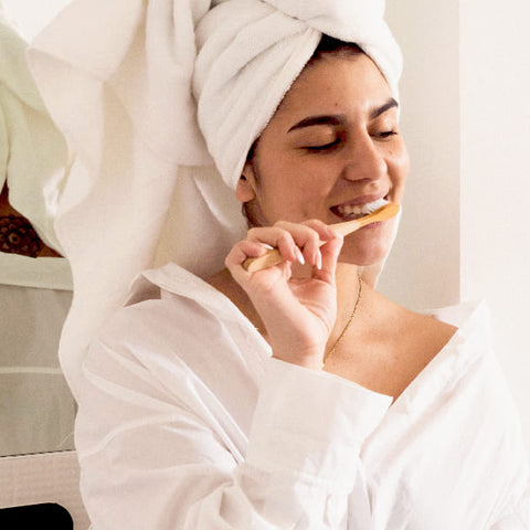 Woman brushing her teeth with a toothbrush