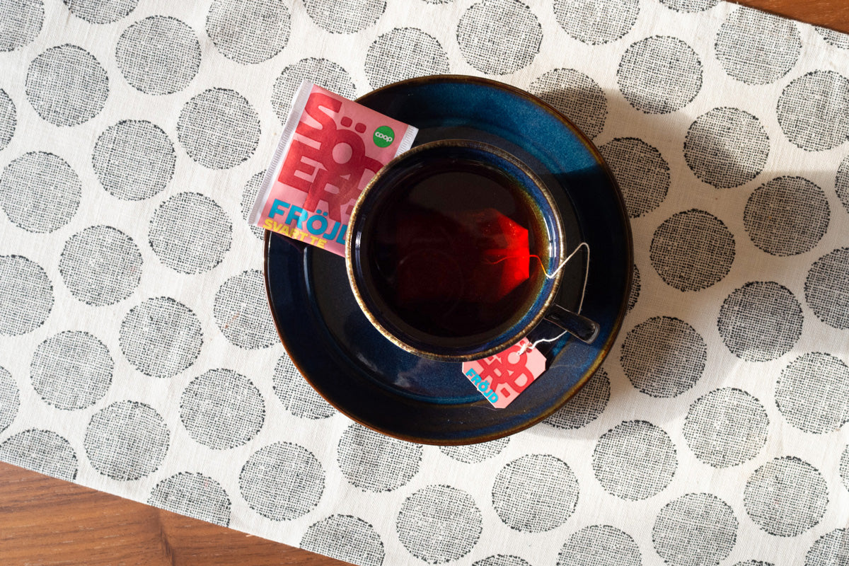 A tea cup containing SÖDERFRÖJD, a harmonious flavored tea that elegantly matches passion fruit, vanilla, and strawberry.