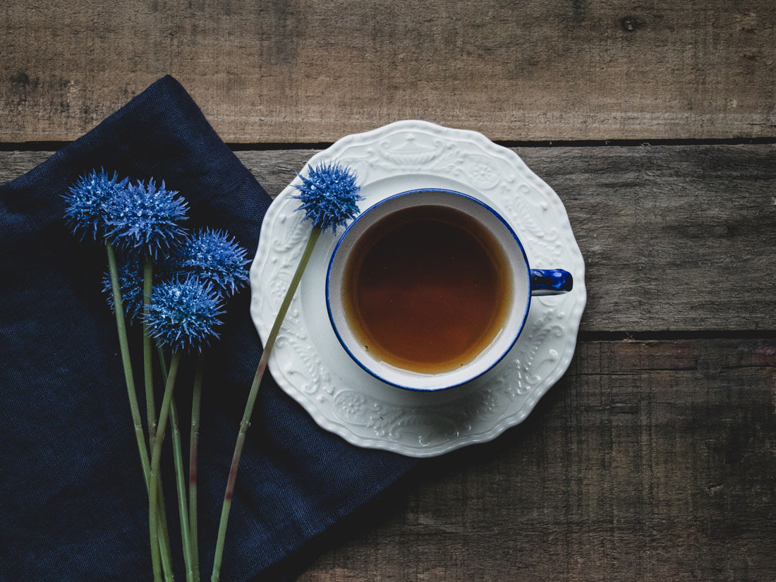 An image of pouring Earl Gray black tea from KOBBS, a Scandinavian Swedish company, into a royal blue tea cup and having a fika.