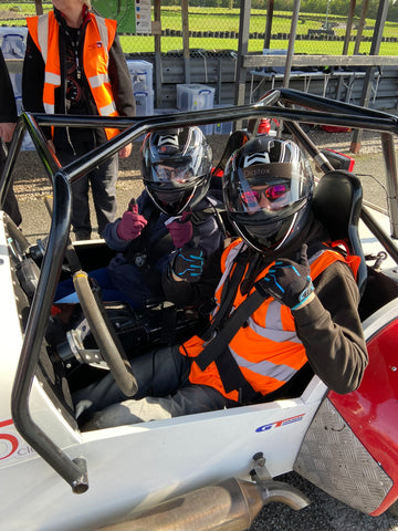 Hayley and her co-driver wearing helmets and sat in an open car during a Speed of Sight track day.