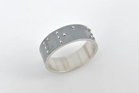 A sterling silver ring with braille
